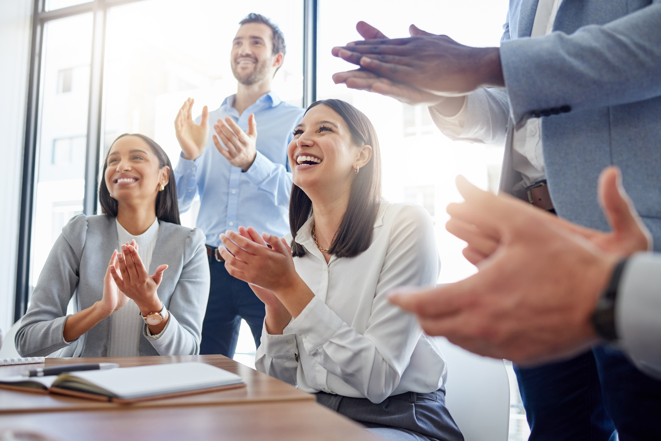 Shot of a group of businesspeople clapping hands in a meeting at work